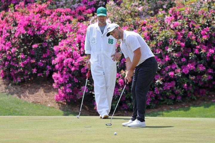 April 7, 2021, Augusta: Jon Rahm putts next to his caddy Adam Hayes on the thirteenth hole during his practice round for the Masters at Augusta National Golf Club on Wednesday, April 7, 2021, in Augusta. Curtis Compton/ccompton@ajc.com