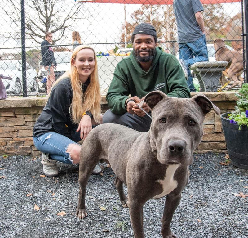 Residents pose with their new dog during the Black Friday weekend adoption special.