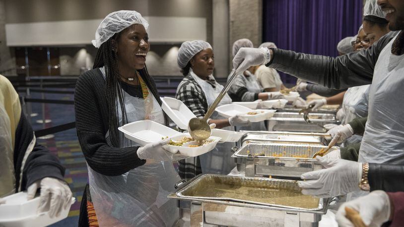 Karson Brown, left, laughs as she prepares a meal during the annual Hosea Helps Thanksgiving dinner at the Georgia World Congress Center in 2017. ALYSSA POINTER/ALYSSA.POINTER@AJC.COM
