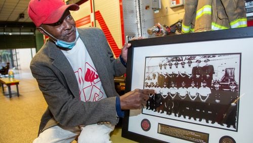 Robert Ware points to himself in a pictures of the 16 original  African-American firefighters at Atlanta Fire Department's Station 16 in Vine City. That station has hosted a community-wide Christmas Party for 50 years. The party had to be cancelled this year due to COVID-19. The station is also where the city's first were employed. PHIL SKINNER FOR THE ATLANTA JOURNAL-CONSTITUTION.