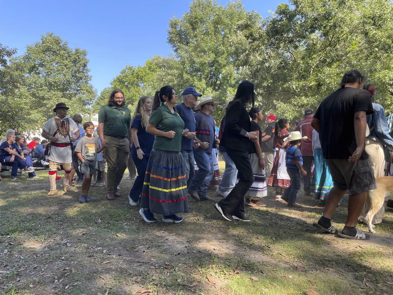 FILE - Tracie Revis, center, joins fellow citizens of the Muscogee (Creek) Nation and visitors to the mounds in an exhibition of a stomp dance at the 30th annual Ocmulgee Indigenous Celebration, Sept. 17, 2022, in Macon, Ga. Georgia's Congressional delegation introduced legislation Wednesday, May 1, 2024, to protect some of the ancestral lands of the Muscogee tribe as a national park and preserve. (AP Photo/Michael Warren, File)