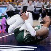 Milwaukee Bucks guard Damian Lillard (0) grabs his leg after being injured during the first half in Game 2 against the Indiana Pacers in an NBA basketball first-round playoff series, Friday, April 26, 2024, in Indianapolis. (AP Photo/Michael Conroy)