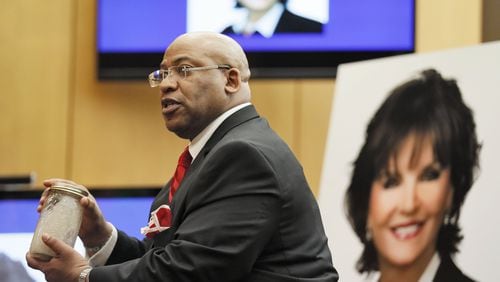 April 17, 2018 - Chief Assistant District Attorney Clint Rucker, with a photo of Diane McIver behind him, holds a jar of sandy water, saying it will be crystal clear when he concludes, as he makes closing arguments for the prosecution during the Tex McIver murder trial at the Fulton County Courthouse.