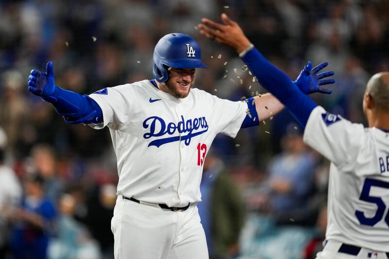 Los Angeles Dodgers' Max Muncy (13) celebrates with Mookie Betts, right, after hitting a home run during the seventh inning of a baseball game against the Atlanta Braves in Los Angeles, Saturday, May 4, 2024. (AP Photo/Ashley Landis)