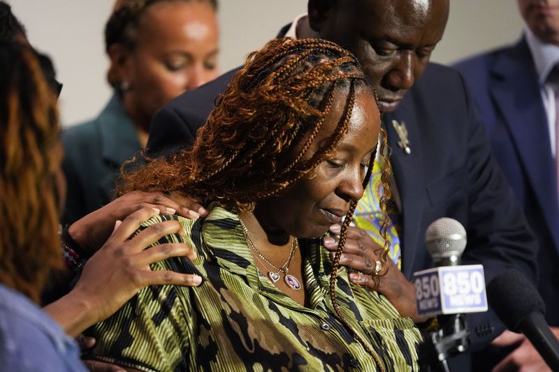 Chantimekki Fortson, mother of Roger Fortson, a U.S. Navy airman, is comforted as she speaks about her son during a news conference regarding his death, with Attorney Ben Crump, behind, Thursday, May 9, 2024, in Ft. Walton Beach, Fla. Fortson was shot and killed by police in his apartment on May 3, 2024. (AP Photo/Gerald Herbert)