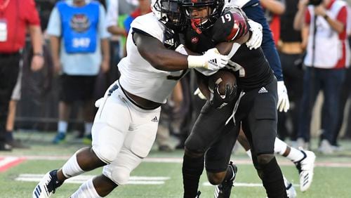 Georgia Tech linebacker Victor Alexander (9) grabs Louisville running back Hassan Hall (19) during the first half of an NCAA college football game, Friday, Oct. 5, 2018, in Louisville, Ky. (AP Photo/Timothy D. Easley)