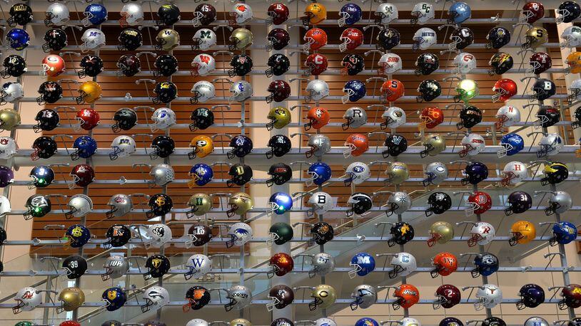Helmets representing college football teams from across the country are on display at the College Football Hall of Fame.  (AJC file photo)