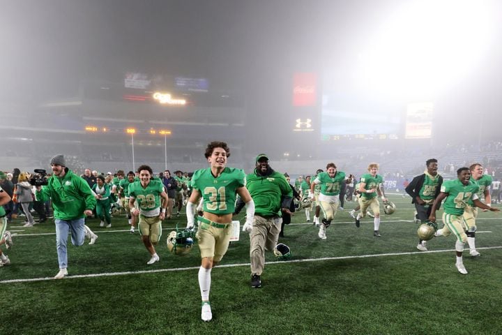 Buford-s Jack Damron (31) and others run toward their student section as they celebrate their 21-20 victory over Langston Hughes during the Class 6A state title football game at Georgia State Center Parc Stadium Friday, December 10, 2021, Atlanta. JASON GETZ FOR THE ATLANTA JOURNAL-CONSTITUTION