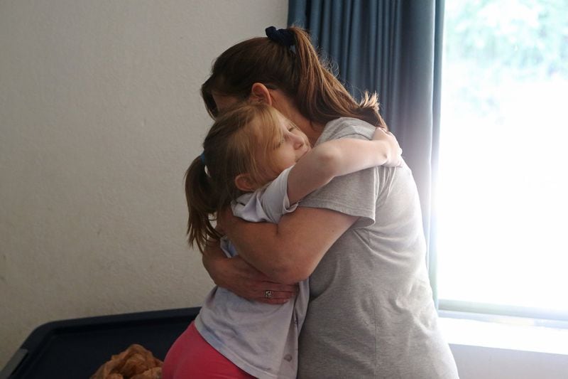Rimbey Schroeder (right) hugs her daughter Sarah (left). The Schroeders wound up living at the Motel 6 in Norcross after moving here from California and living in their car for several months. CHRISTINA MATACOTTA / CHRISTINA.MATACOTTA@AJC.COM