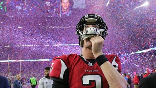 Falcons quarterback Matt Ryan reacts to losing the Super Bowl to New England 34-28 in overtime as the video board shows Patriots quarterback Tom Brady and the confetti drops in Houston’s NRG Stadium. (Curtis Compton/ccompton@ajc.com)