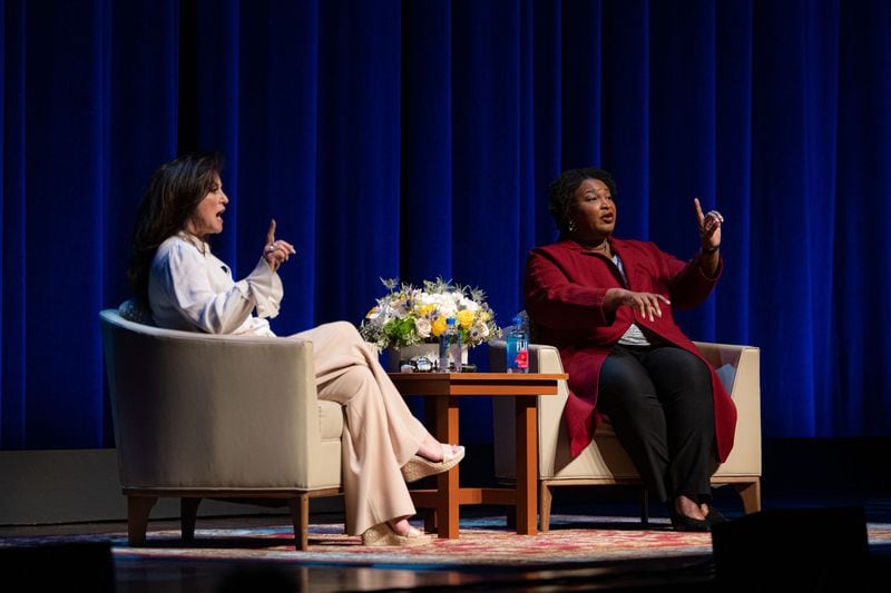 Stacey Abrams, right, raises a hand to quiet a crowd in San Antonio while making a point about politics.