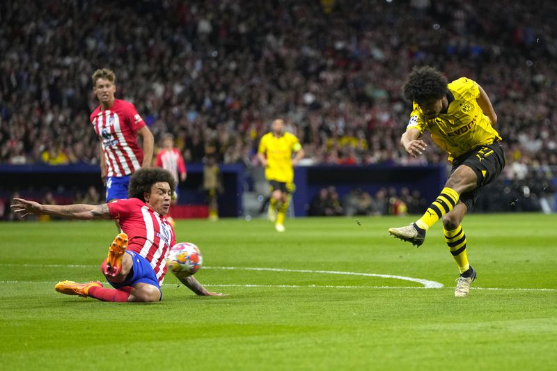 Dortmund's Karim Adeyemi, right, makes an attempt to score past Atletico Madrid's Axel Witsel during the Champions League quarterfinal soccer match between Atletico Madrid and Borussia Dortmund at the Metropolitano stadium in Madrid, Spain, Wednesday, April 10, 2024. (AP Photo/Manu Fernandez)