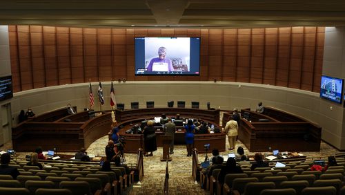 Commissioners and the public listen to a virtual call during a meeting at the Fulton County government building in Atlanta, on Wednesday, May 5, 2021. (Rebecca Wright for the Atlanta Journal-Constitution)