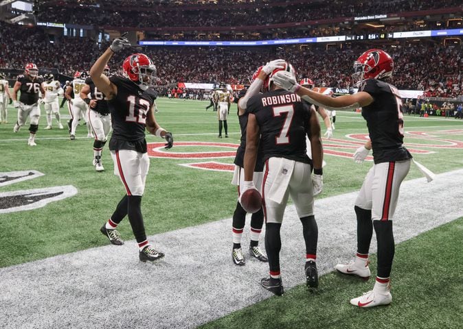 Atlanta Falcons running back Bijan Robinson (7) is congratulated in the end zone after scoring a first half touchdown against the New Orleans Saints in Atlanta on Sunday, Nov. 26, 2023.   (Bob Andres for the Atlanta Journal Constitution)
