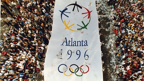 Atlanta, GA - Olympics parade - An Atlanta 1996 Olympic banner makes it's way north along Peachtree Street in downtown Atlanta Monday, September 24, 1990 celebrating Atlanta's having been awarded the 1996 Summer Olympics. (JOEY IVANSCO/ AJC staff)