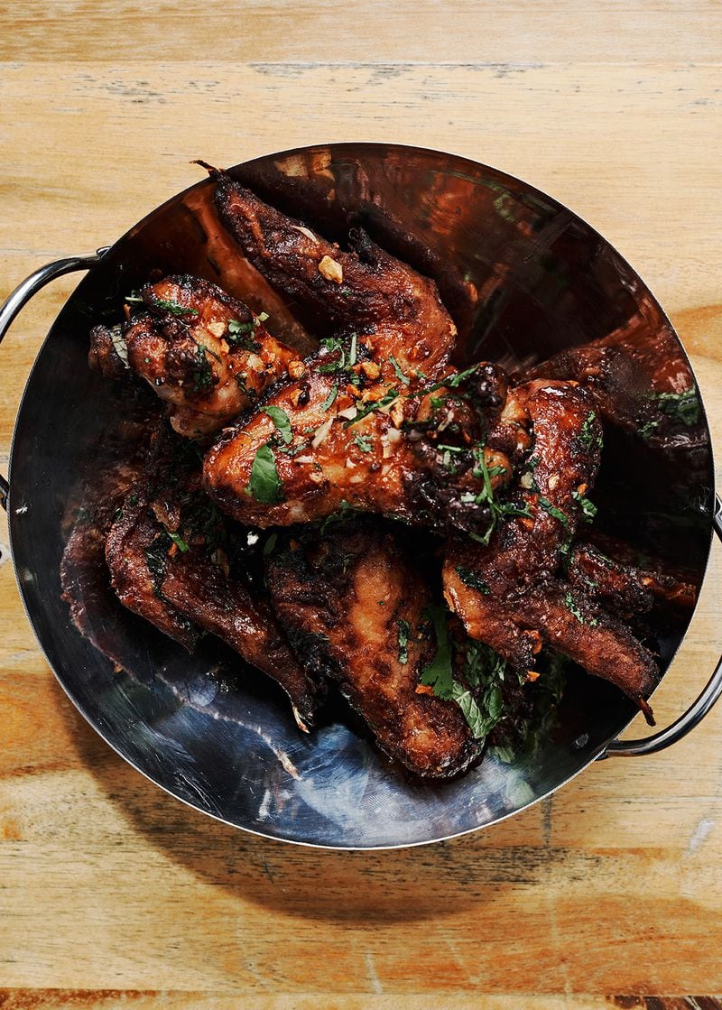 Tossed with fried garlic, mint and cilantro, Thai Sticky Wings are a recent specialty item on the menu at Tuk Tuk Thai Food Loft.  / Courtesy of DeeDee Niyomkul