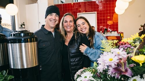 Owner of Warm Waves Coffee Kenny Libby (left) poses with wife Shawn Libby (middle) and daughter Brooke Libby (right) at the grand opening of their newest cafe location.