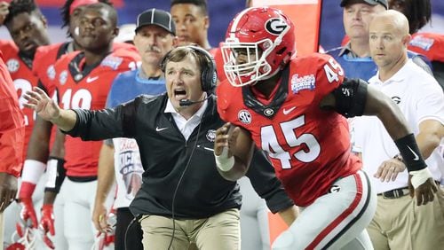 090316 ATLANTA: Georgia head coach Kirby Smart makes a defensive adjustment while Reggie Carter runs to the field against North Carolina in the Chick-fil-A Kickoff Game on Saturday, Sept. 3, 2016, in Atlanta.   Curtis Compton /ccompton@ajc.com