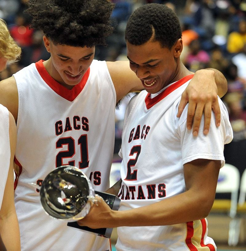 MARCH 6, 2014 MACON Greater Atlanta Christian Spartans Isaiah Wilkins #21 and Greater Atlanta Christian Spartans Eric Jamison #2 look at the trophy after the game. Coverage of the Class AA boys basketball championship between Greater Atlanta Christian Spartans and Calhoun Yellowjackets at the Macon Coliseum Friday, March 7, 2014. The Greater Atlanta Christian Spartans beat the Calhoun Yellowjackets 58-55 for the championship. KENT D. JOHNSON / KDJOHNSON@AJC.COM Greater Atlanta Christian's Isaiah Wilkins (left) and Eric Jamison look over the Class AA championship trophy after the Spartans' 58-55 win over Calhoun in the state title game Friday, March 7, 2014, in Macon. (Kent D. Johnson / AJC)