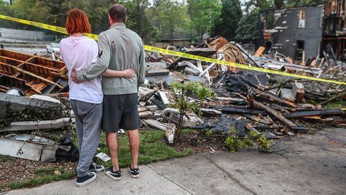 Kristen Sanchez (left) and boyfriend Nikolas Waldschuetz look at what's left of the North High Ridge Apartments on North Avenue after a devastating fire. Waldschuetz and 27 other residents lost their homes in the blaze.