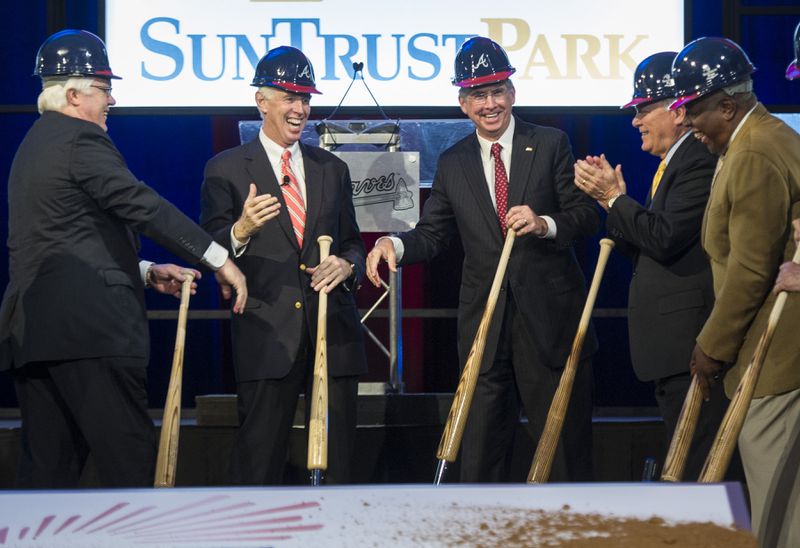 Cobb County chairman Tim Lee, left, Atlanta Braves chairman Terry McGuirk, second from left, SunTrust CEO William Rogers, third from left, Georgia Gov. Nathan Deal, second from right, and Hall of Fame baseball player Hank Aaron, right, wrap up a ground breaking ceremony Tuesday, Sept. 16, 2014, in Atlanta, for the Atlanta Braves new baseball stadium, which will be called SuntTust Park. (AP Photo/John Amis)
