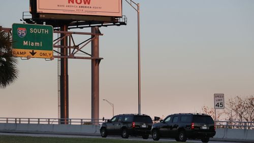 Vehicles from the motorcade carrying President Donald Trump pass a billboard reading: 'Impeachment Now Make America America Again!' as he is driven to Mar-A-Lago on March 23, 2018 in West Palm Beach, Fla. (Photo by Joe Raedle/Getty Images)
