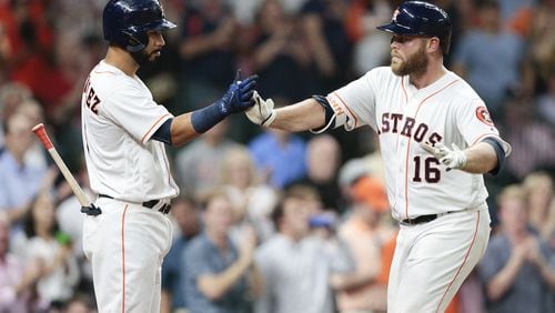 Brian McCann (right) is congratulated by Marwin Gonzalez after hitting a home run against Seattle earlier this season. BOB LEVEY/GETTY IMAGES