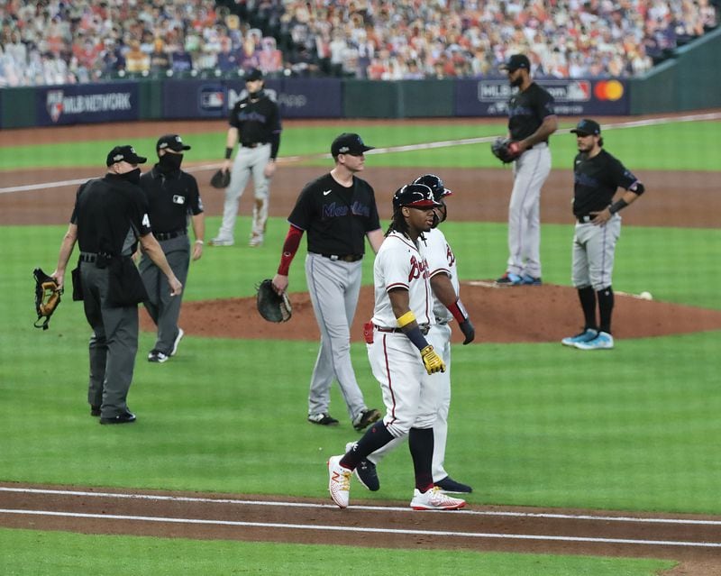 Braves outfielder Ronald Acuna is walked to first base by coach DeMarlo Hale after getting hit by Miami Marlins pitcher Sandy Alcantara in the third inning in Game 1 of a National League Division Series at Minute Maid Park on Tuesday, Oct. 6, 2020, in Houston. (Curtis Compton / Curtis.Compton@ajc.com)