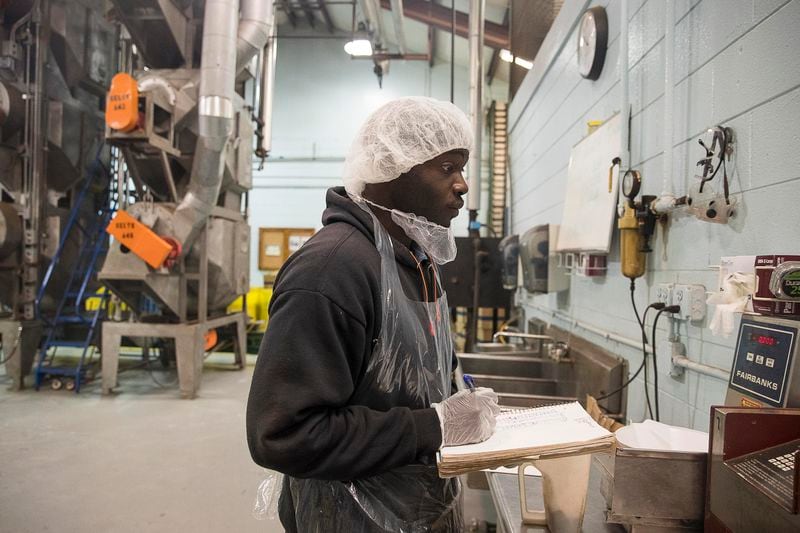 03/18/2019 -- Albany, Georgia -- Monquez Toomer takes notes on a batch of pecans while working in the shelling unit at Sunnyland Farms in Albany, Monday, March 18, 2019. Toomer relies on his friend to get him to and from work because he does not have a reliable mode of transportation. He pays his friend $20 every week to get him to Sunnyland Farms. (ALYSSA POINTER/ALYSSA.POINTER@AJC.COM)