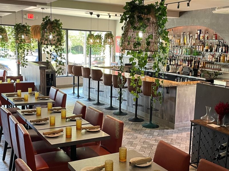 The 60-seat dining room at La Panarda is bright with natural light and hanging greenery. Courtesy of La Panarda