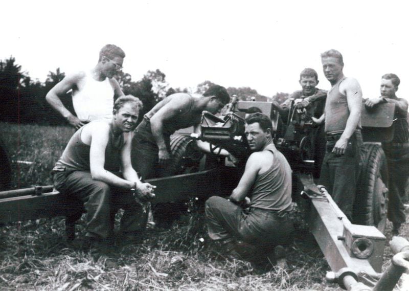 Hilbert Margol and his Howitzer (105 mm) crew during World War II. He said they had just cleaned the gun and he was leaning over, checking the weapon’s mechanism. Photo from Hilbert Margol