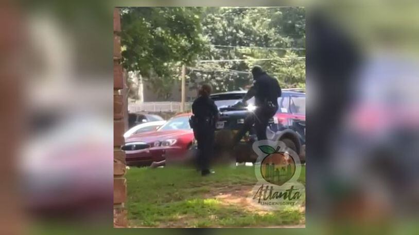 Two Atlanta police officers were suspended after a video surfaced on social media that shows one of them kicking a woman in the face as she lay handcuffed on the ground.