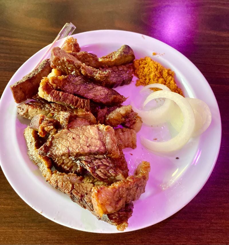 A good way to start your meal at the Island Grill is with a plate of suya, a  grilled beef snack that is typical of street food in Nigeria. It goes well with beer. Wendell Brock for The Atlanta Journal-Constitution