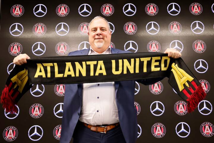Atlanta United CEO/President Garth Lagerwey poses with the Atlanta United scarf after being introduced during his  news conference Tuesday at Mercedes-Benz Stadium. (Miguel Martinez / miguel.martinezjimenez@ajc.com)