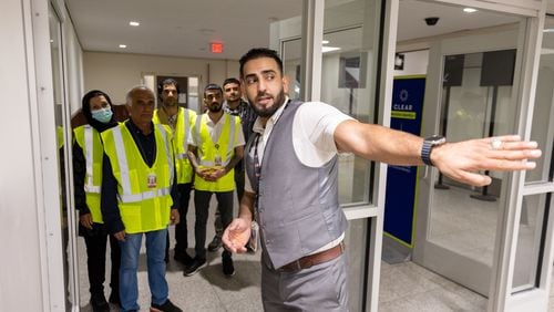 Mirwais Jalali, a recruiter for aviation contractor Unifi, gives new employees a tour of the Hartsfield-Jackson airport in Atlanta in April. To expand the candidate pool, some employers are hiring immigrants, people with disabilities, formerly incarcerated people and veterans,  (Arvin Temkar / arvin.temkar@ajc.com)