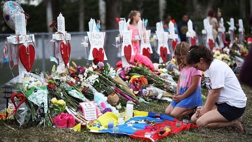 People visit a makeshift memorial setup in front of Marjory Stoneman Douglas High School. (Photo by Joe Raedle/Getty Images)