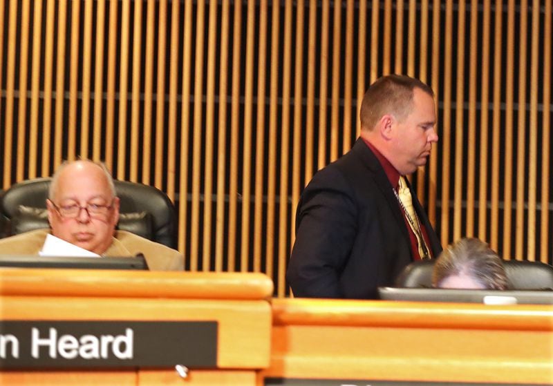 Tommy Hunter (right), the District 3 leader that recently called U.S. Rep. John Lewis a “racist pig” on Facebook, walks out just before public comments as more protesters demand his resignation during the Gwinnett County Board of Commissioners public hearing session Tuesday. Curtis Compton/ccompton@ajc.com