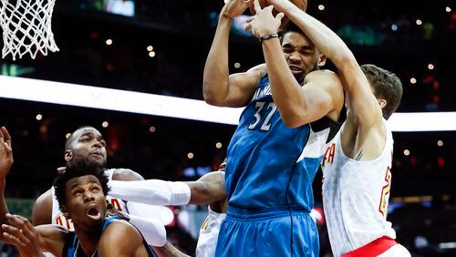 Minnesota Timberwolves center Karl-Anthony Towns (32) and Atlanta Hawks guard Kyle Korver (26) battle for a rebound as Minnesota forward Andrew Wiggins (22) looks on at left in the second half of an NBA basketball game Wednesday, Dec. 21, 2016, in Atlanta. Minnesota won 92-84. (AP Photo/John Bazemore)