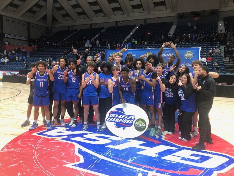 The Riverwood basketball teams stands with the Class 6A state championship trophy they won by beating Alexander 67-63 in OT on March 8, 2024 at the Macon Coliseum.