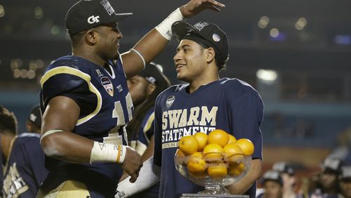 Georgia Tech quarterback Justin Thomas, right, is congratulated by running back Synjyn Days after Thomas was presented with the MVP trophy after Georgia Tech defeated Mississippi State 49-34 in the Orange Bowl NCAA college football game, Wednesday, Dec. 31, 2014, in Miami Gardens, Fla. (AP Photo/Wilfredo Lee)