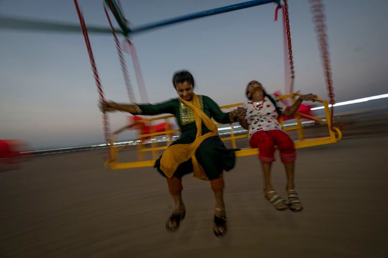 A mother and daughter enjoy a ride on Marina beach in the southern Indian city of Chennai, April 16, 2024. (AP Photo/Altaf Qadri)