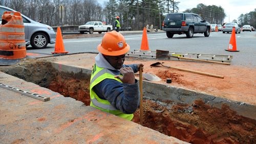 Glen Alston of  Butch Thompson Enterprises, Inc. works to install a water main at Kennesaw Due West Road and Stilesboro Road in preparation of widening Stilesboro Road in March 2010.