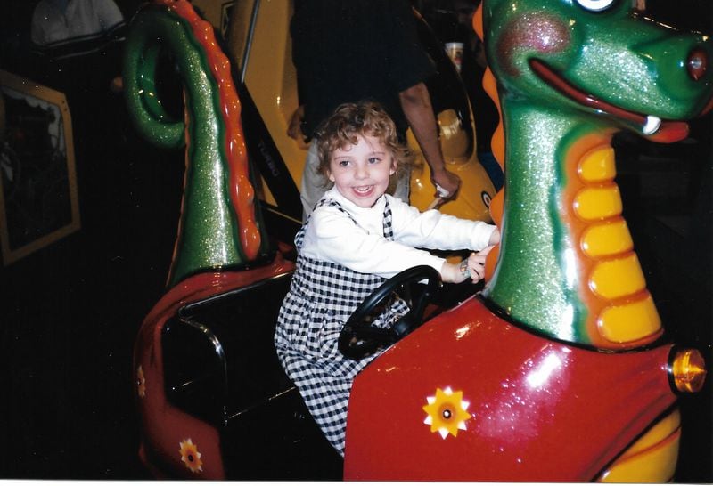 Olivia King rides a “dragon” during her fifth birthday party at Chuck E. Cheese in Norcross. (Courtesy of the King family)