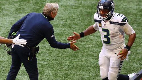 Seahawks quarterback Russell Wilson is greeted by head coach Pete Carroll on the sidelines during the third quarter Sunday, Sept. 13, 2020, at Mercedes-Benz Stadium in Atlanta. The NFL reminded coaches of face covering mandates on the field following Week 1 games.