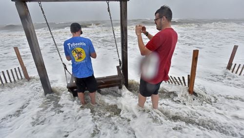 Tybee Island - Brett Lay (left) and James Simpson snap pictures as Hurricane Dorian approaches Wednesday, September 4, 2019.