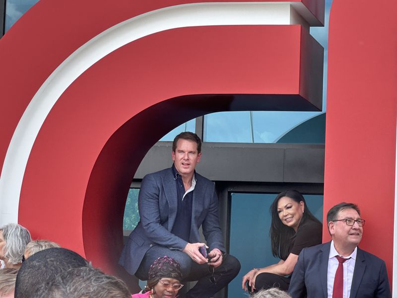 Former CNN anchors Thomas Roberts and Sophia Choi sit in the letter C of the CNN logo during the CNN Center farewell legacy party on June 1, 2023. RODNEY HO/rho@ajc.com