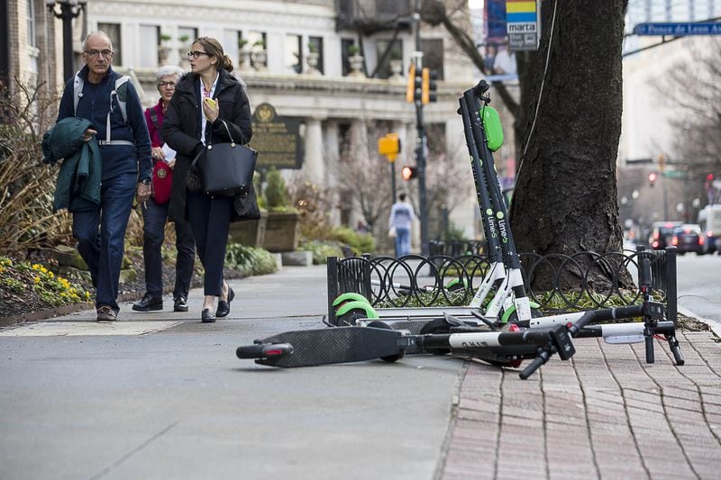  Pedestrians walk passed Lime and Bird scooters that are parked on the sidewalk of Peachtree Street in Atlanta’s Midtown community, Friday, January 4, 2019. (ALYSSA POINTER/ALYSSA.POINTER@AJC.COM)