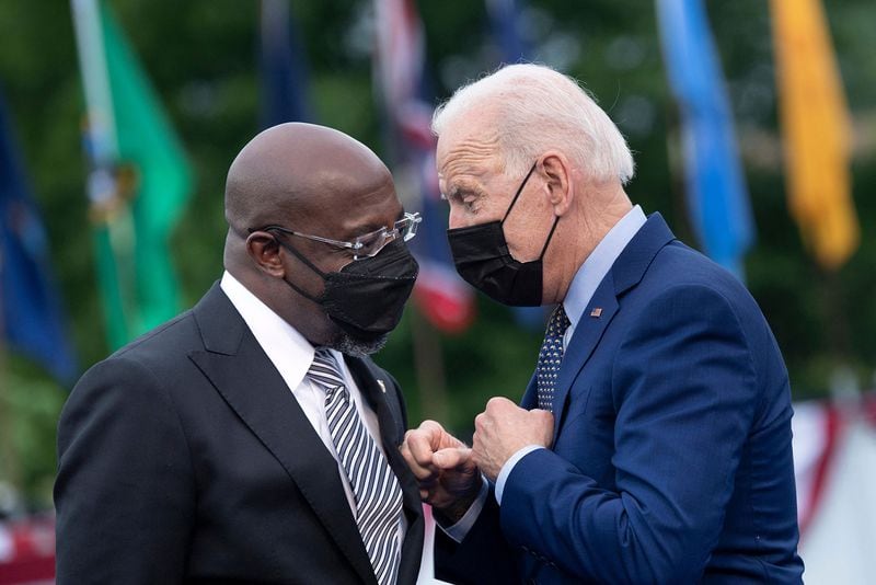 Democratic U.S. Sen. Raphael Warnock, left, has tried during this campaign to separate himself from President Joe Biden, who's approval rating -- while rising in some other battleground states -- has not budged from a similar poll in July. (Brendan Smialowski/AFP via Getty Images/TNS)