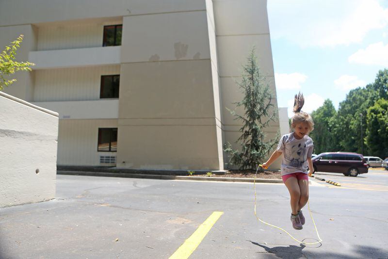 Sarah Schroeder, 8, jumps rope in the parking lot at the extended-stay motel where her family has been living. CHRISTINA MATACOTTA / CHRISTINA.MATACOTTA@AJC.COM