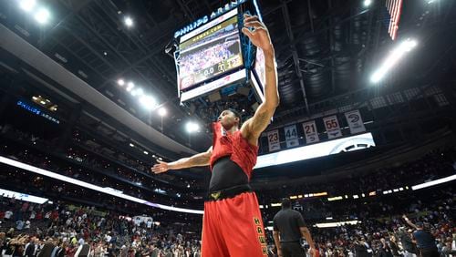 Kent Bazemore raises his arms in victory in an NBA game between the Atlanta Hawks and Cleveland Cavaliers at Phillips Arena in Atlanta, Georgia, on April 9, 2017. The Hawks beat the Cavaliers 126-125 in overtime after coming back after being down 26 points in the fourth quarter. (HENRY TAYLOR / HENRY.TAYLOR@AJC.COM)